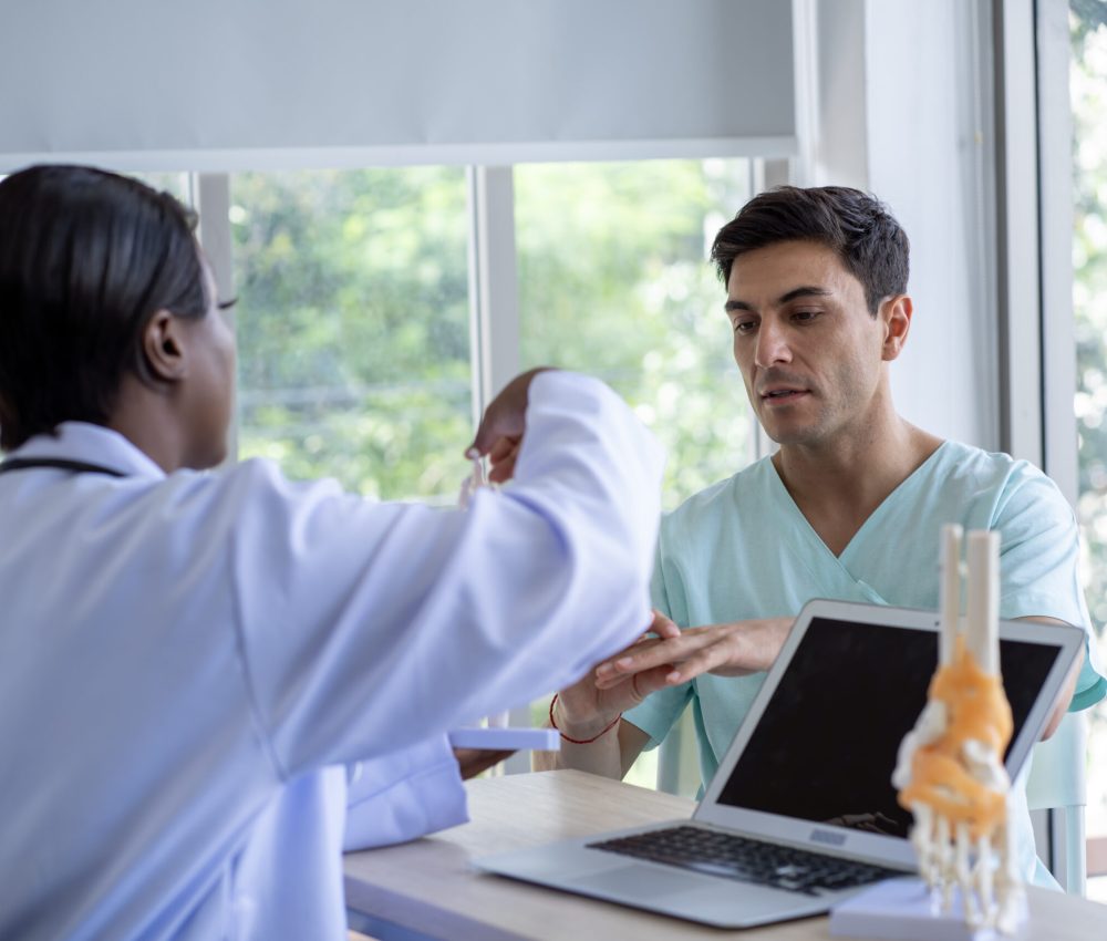Female doctor and male patient Discuss and give advice about wrist and arm pain among patients in the hospital.